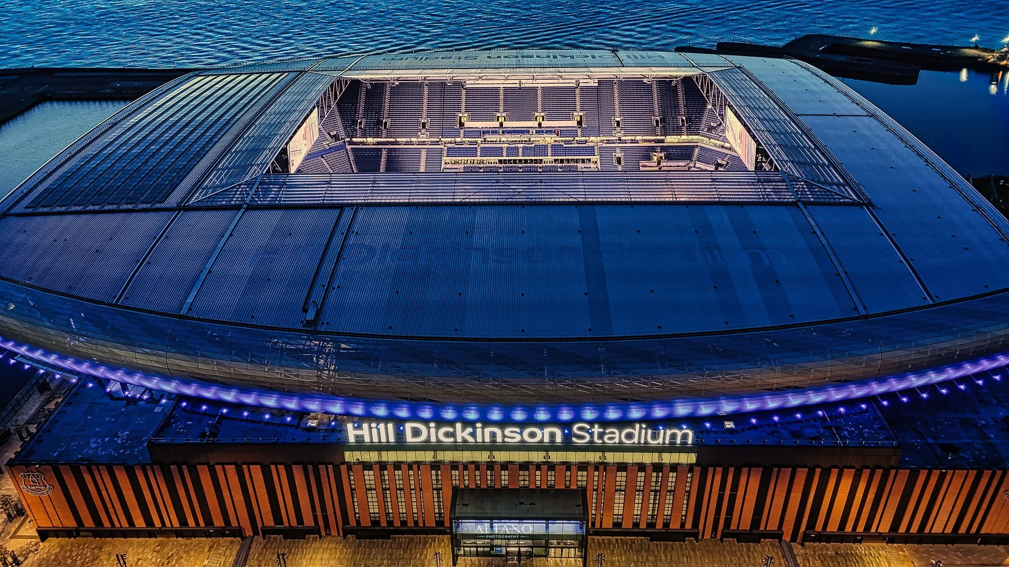 Hill Dickinson Stadium reflected in the dock water at night